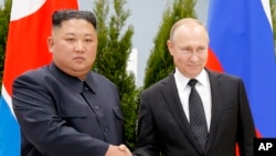 Kiongozi wa Korea Kaskazini Kim Jong Un na Rais wa Russia Vladimir Putin wakisalimiana wakati wa mkutano wao katika mji wa Russia wa Vladivostok, Aprili 25, 2019.