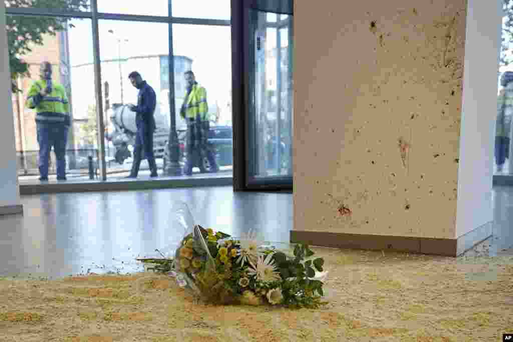 Flowers laid in tribute inside an office building in Brussels, at the scene close to where two Swedish soccer fans were shot by a suspected Tunisian extremist on Monday night.&nbsp;Police in Belgium have shot dead a suspected Tunisian extremist accused of killing two Swedish soccer fans in a brazen attack on a Brussels street before disappearing into the night on Monday. (AP Photo/Martin Meissner)