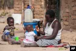 Children eat porridge prepared at a feeding center in Mudzi, Zimbabwe, on July 2, 2024. In Zimbabwe, an El Nino-induced drought is affecting millions of people, and children are most at risk. (AP Photo/Aaron Ufumeli)