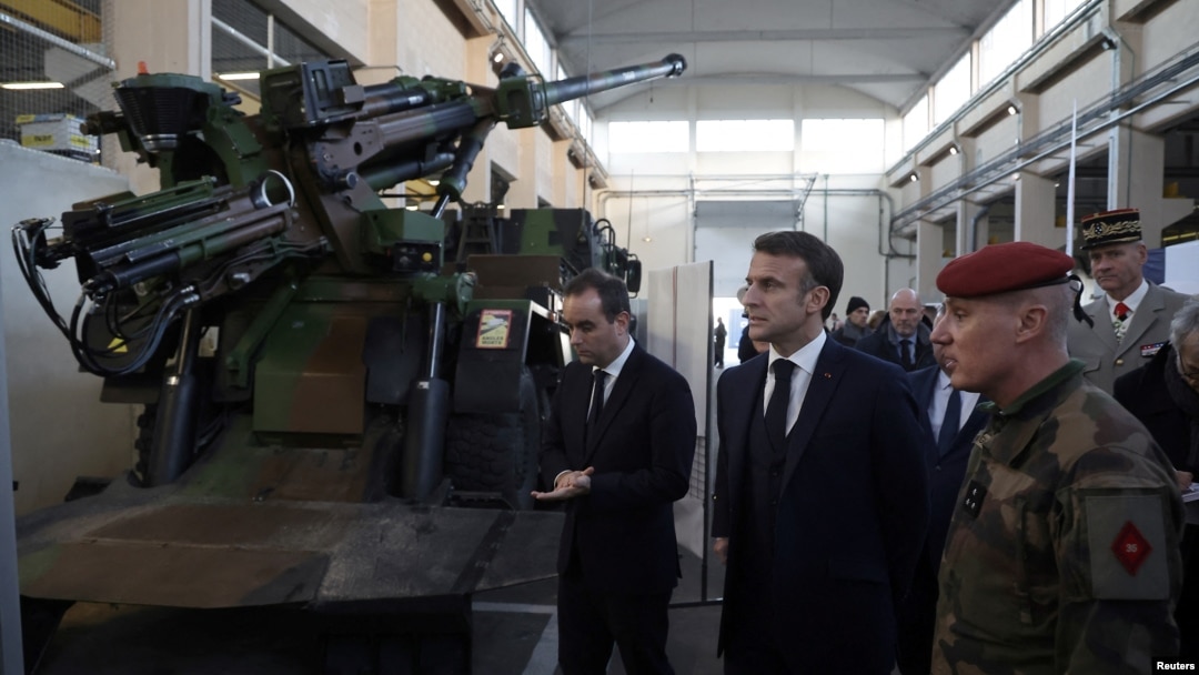 French President Emmanuel Macron inspects a Caesar artillery system during a visit to the Cherbourg naval base as part of his New Year's wishes to the French army, in Cherbourg, northwestern France, 19 Jan. 2024.