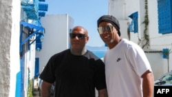 Le rappeur K2Rhym pose aux côtés du footballeur brésilien à la retraite Ronaldinho (d) à Sidi Bou Said, au nord-est de la capitale Tunis, le 20 mai 2022. 