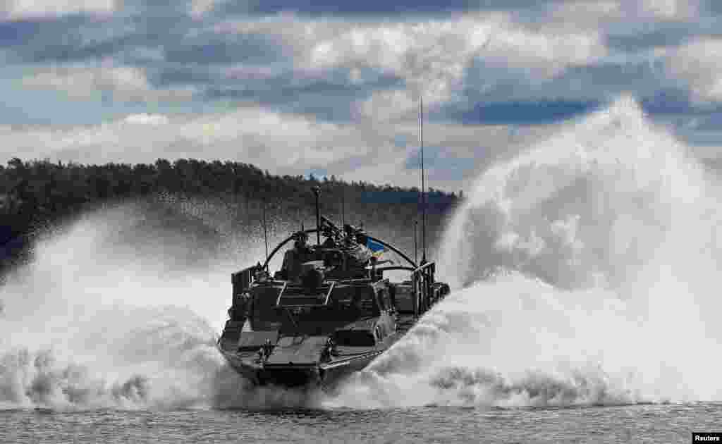 A Swedish battleship 90 makes a crash stop as Swedish amphibious soldiers practice with Finnish amphibious soldiers from the Nylands brigade during the military exercise Aurora 23 at Berga naval base outside Stockholm. (TT News Agency/Andres Wiklund via Reuters)