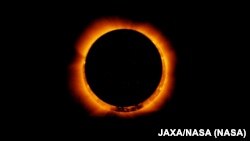 FILE— Photo of an annular solar eclipse taken by the solar optical telescope Hinode as the Moon came between it and the Sun.