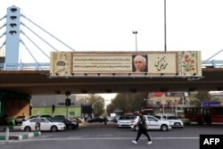 Traffic flows under a billboard installed on a pedestrian bridge by the Iranian capital's municipality, in Tehran, Oct. 30, 2023.