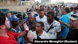 Un hombre intenta organizar una fila de personas que esperan para repostar combustible en una gasolinera en La Habana, Cuba, el 22 de abril de 2023.
