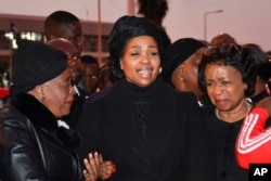 Wife of Vice President Saulos Chilima, Mary Chilima, center, is comforted by Malawi First Lady Monica Chakwera, left, at Kamuzu International Airport in Lilongwe, June 11, 2024, as they await the body of the vice president and nine others killed in a plane crash.