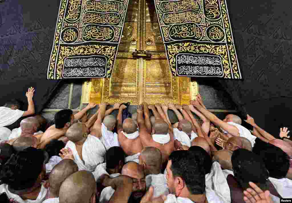 Muslims touch and pray at the door of the Kaaba during their Umrah, at the Grand Mosque, in the holy city of Mecca, Saudi Arabia, Dec. 18, 2023.