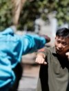 FILE - Chinese national Jack Wang, a security trainer at the Chinese-run DeWe Security Service, leads Kenyan security guards in martial arts combat training at their company compound in Nairobi, March 13, 2017. 