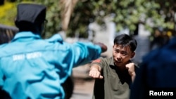 FILE - Chinese national Jack Wang, a security trainer at the Chinese-run DeWe Security Service, leads Kenyan security guards in martial arts combat training at their company compound in Nairobi, March 13, 2017. 