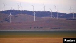 A fence is seen in front of wind turbines that are part of the Infigen Energy Capital Wind Farm located on the hills surrounding Lake George, near the Australian capital city of Canberra, Australia Feb. 21, 2018. 
