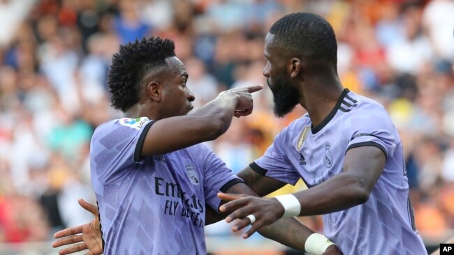 Real Madrid's Vinicius Junior, left, confronts Valencia fans as Antonio Rudiger tries to calm him down during a Spanish La Liga soccer match between Valencia and Real Madrid, at the Mestalla stadium in Valencia, Spain, May 21, 2023.
