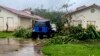 En esta foto proporcionada por la Guardia Costera de EEUU, ramas de árboles caídas ensucian un vecindario en Yona, Guam, el 25 de mayo de 2023, después de que el tifón Mawar pasara por la isla.