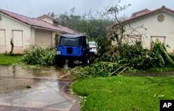 In this photo provided by the U.S. Coast Guard, downed tree branches litter a neighborhood in Yona, Guam, May 25, 2023, after Typhoon Mawar passed over the island.