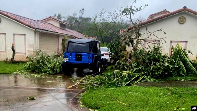 In this photo provided by the U.S. Coast Guard, downed tree branches litter a neighborhood in Yona, Guam, May 25, 2023, after Typhoon Mawar passed over the island.