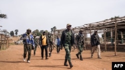 FILE: Commanders of the armed group URDPC/CODECO (Union des Révolutionnaires pour la Défense du Peuple Congolais/Coopérative pour le Développement du Congo) walk through the village of Linga on January 13, 2022, in Ituri province, northeastern Democratic Republic of Congo. 