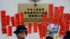 2019年1月29日，警方在香港“中聯辦”外走過支持被監禁的中國人權律師王全璋的標語牌。 （法新社照片）