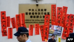 资料照片：2019年1月29日，警察在香港“中联办”外走过支持被监禁的中国人权律师王全璋的标语牌。（法新社照片）