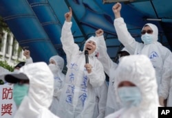 FILE - Medical workers protest to ask for increasing labor welfare during a May Day rally in Taipei, Taiwan, May 1, 2023. The term 山道猴子 (shan dao hou zi), "mountain roadmonkey," became popular for young people facing economic pressures. (AP Photo/Chiang Ying-ying)