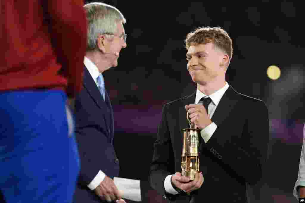 Durante la ceremonia, el múltiple medallista de oro, León Marchand, portó la llama de París que se apagó durante la clausura, para dejar que brille rumbo a Los Ángeles 2028.