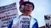 ARCHIVO - Rory Healy, nacida en Atlanta, Georgia, usa una camisa que lee "ambos partidos apestan", durante una protesta en contra de la guerra con Irán el sábado, 4 de febrero de 2012. [AP]