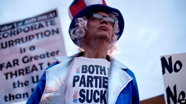 ARCHIVO - Rory Healy, nacida en Atlanta, Georgia, usa una camisa que lee "ambos partidos apestan", durante una protesta en contra de la guerra con Irán el sábado, 4 de febrero de 2012. [AP]