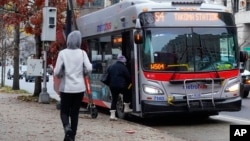 FILE - Passengers boarding a Metrobus in downtown Washington, Dec. 7, 2022.