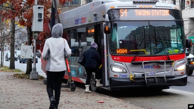 FILE - Passengers boarding a Metrobus in downtown Washington, Dec. 7, 2022.