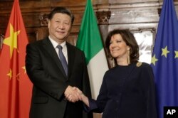 FILE - Italian senate speaker Maria Elisabetta Alberti Casellati greets Chinese President Xi Jinping as he visits the senate in Rome on March 22, 2019. Xi was there to sign a memorandum of understanding to make Italy a member of China's Belt and Road Initiative.