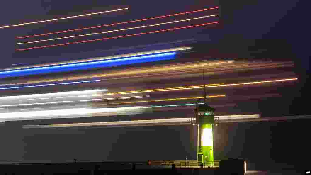 Траект поминува низ мал светилник на влезот од пристаништето во Травемуенде, северна Германија.