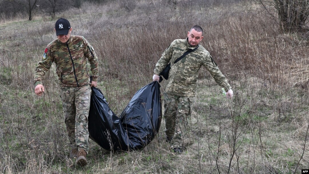 Članovi ukrajinskog civilno-vojnog tima nose tijelo ubijenog ruskog vojnika u selu Sinika u regionu Harkiv.