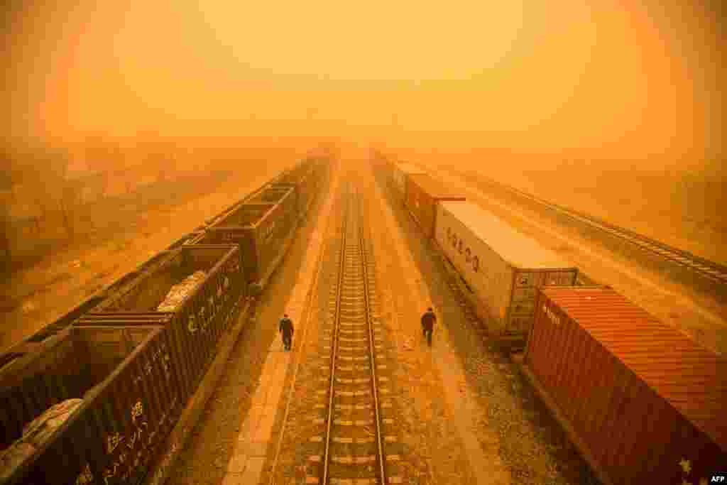 Police officers check train cars at a border checkpoint during a sandstorm in the border city of Erenhot, in China's northern Inner Mongolia region, March 21, 2023.