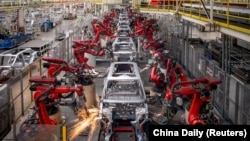 (FILE) Robotic arms assemble cars in the production line for Leapmotor's electric vehicles at a factory in Jinhua, Zhejiang province, China, April 26, 2023.