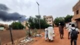 FILE: Smoke rises above buildings as people flee with some belongings, in Khartoum, Sudan, June 10, 2023. Fighting resumed after the e3nd of the 24-hour-long cease fire.
