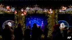 Pembeli dan pejalan kaki melewati etalase di Saks Fifth Avenue di New York, Kamis, 14 Desember 2023. (AP Photo/Peter K. Afriyie)