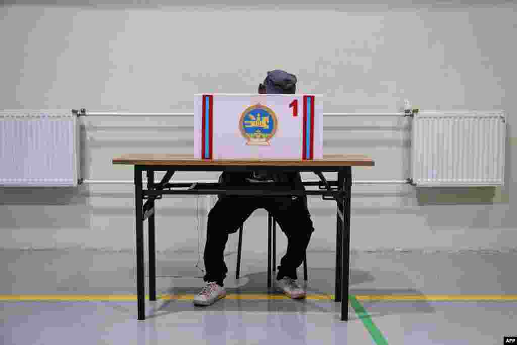 A man votes in the Mongolian parliamentary elections at a polling station in the Bayanzurkh district in Ulaanbaatar, Mongolia.