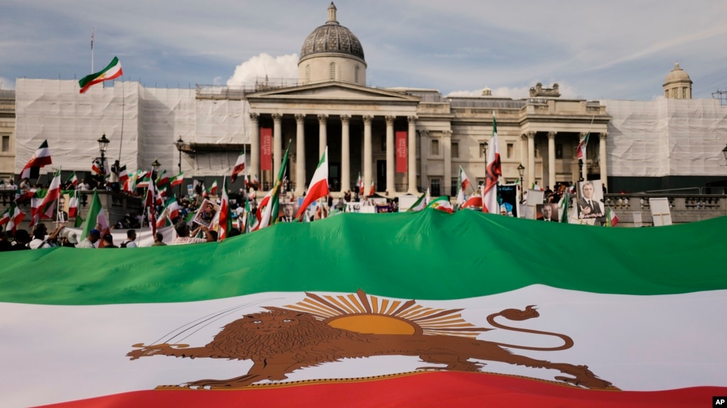 Demonstrators display a giant pre-revolution Iran flag as they gather in Trafalgar Square in London on Sept. 16, 2023, marking the anniversary of the death of Mahsa Amini in Iran.