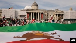 Demonstrators display a giant pre-revolution Iran flag as they gather in Trafalgar Square in London on Sept. 16, 2023, marking the anniversary of the death of Mahsa Amini in Iran.
