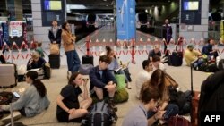 Passengers wait for their train departures at the Gare Montparnasse in Paris, July 26, 2024, as France's high-speed rail network was hit by malicious acts disrupting the transport system hours before the opening ceremony of the Paris 2024 Olympic Games.