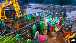 This photograph provided by PRO Defense Kochi shows Indian army soldiers assembling a prefabricated bridge across a river on the second day of rescue operations at a landslide affected village in Wayanad in southern Kerala, India, July 31, 2024.