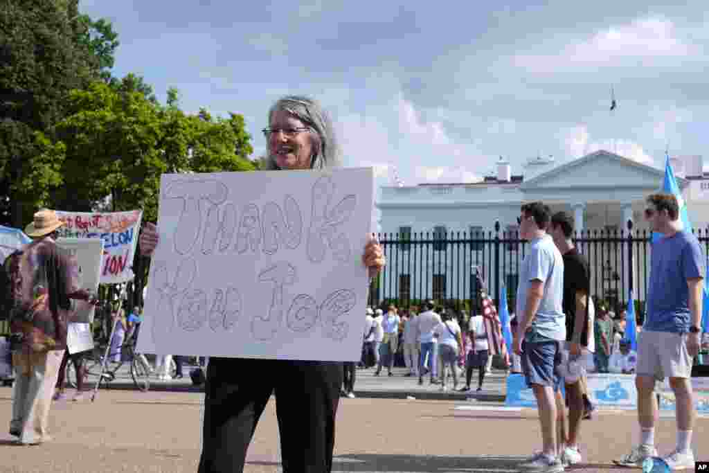 La residente en Washington, Patricia Greene, sostiene un cartel agradeciendo al presidente Joe Biden.