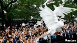 资料照：2023年8月15日，日本东京，在日本二战投降78周年之际，人们在参拜靖国神社时放飞鸽子。（路透社） 