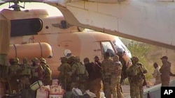 FILE - This undated photograph handed out by French military shows Russian mercenaries boarding a helicopter in northern Mali. 