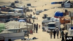 Displaced Palestinians walk amidst tents in Rafah in the southern Gaza Strip, on May 31, 2024.