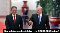 Perdana Menteri Rusia Mikhail Mishustin dan Perdana Menteri China Li Qiang tiba di Aula Besar Rakyat di Beijing, China, 24 Mei 2023. (Foto: Sputnik/Alexander Astafyev via REUTERS)