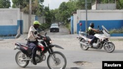 FILE - Members of Haitian National Police (PNH) lead a convoy of cars carrying members of a Kenyan delegation as they leave the premises of the police after meeting with the Chief of the PNH Frantz Elbe, in Port-au-Prince, Haiti, August 21, 2023.