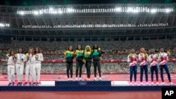 Gold medalist team Jamaica, center, stands with silver medalist United States, left, and bronze medalist Britain during the medal ceremony for the women's 4 x 100-meter relay at the 2020 Summer Olympics, Aug. 7, 2021, in Tokyo.