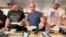 Maksym Bunchukov, Andrii Hryshchuk and Ivan Sakivskyi help themselves to perogies at a lunch hosted, July 17, 2023, by the Ukrainian Cultural Institute in Dickinson, North Dakota. 