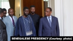This handout picture distributed by the Senegalese Presidency on March 28, 2024 shows opposition leader Ousmane Sonko (2nd R), outgoing Senegalese President Macky Sall (R) and Senegal's president-elect Bassirou Diomaye Faye (3rd R) walking at the Presidential palace in Dakar.