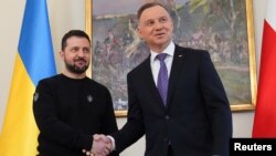 El presidente de Polonia, Andrzej Duda, y el presidente de Ucrania, Volodymyr Zelenskiy, se dan la mano cuando se reúnen en el Palacio Presidencial de Varsovia, Polonia, el 5 de abril de 2023. REUTERS/Aleksandra Szmigiel