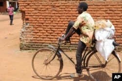 A man carries bags of fertilizer on his bicycle in Lilongwe, Malawi, on March 6, 2023. The Russian government has donated 20,000 tons of fertilizer to Malawi as part of its efforts to garner diplomatic support from various African nations.